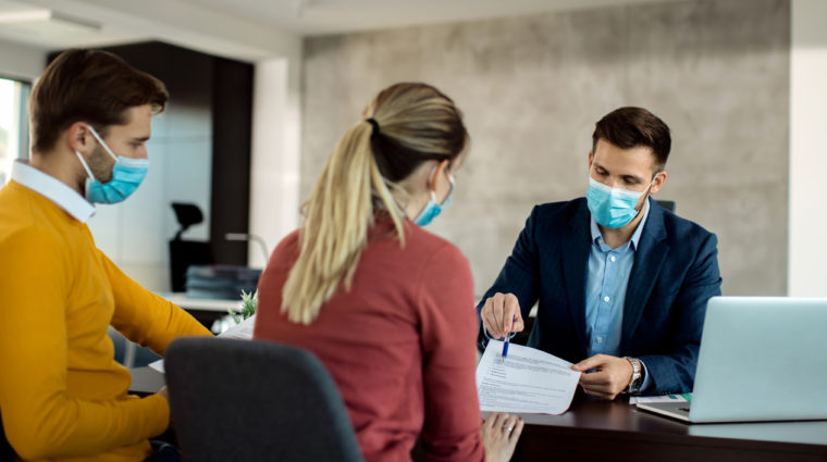 Financial planner meeting with couple with face masks during pandemic