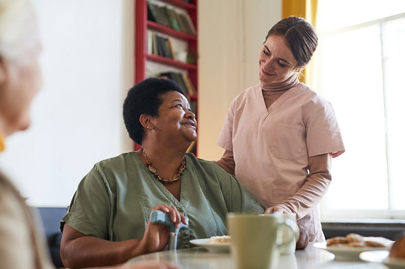 Professional caring for an older woman in assisted living facility
