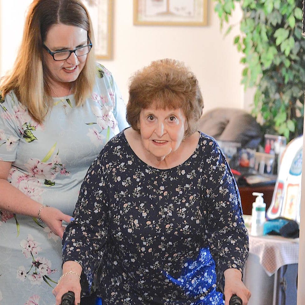 Caregiver helping older lady in her home