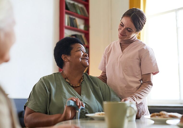 Professional caring for an older woman in assisted living facility