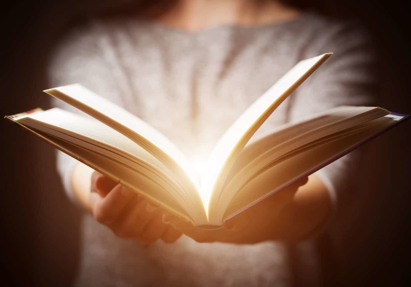 Light Coming From Book In Woman's Hands In Gesture Of Giving Light coming from book in woman's hands in gesture of giving, offering. Concept of wisdom, religion, reading, imagination.